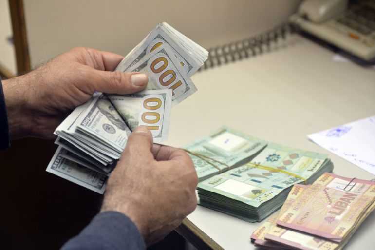 An exchange dealer shows money at a currency exchange office as the value of the Lebanese currency against the US dollar continues to drop.