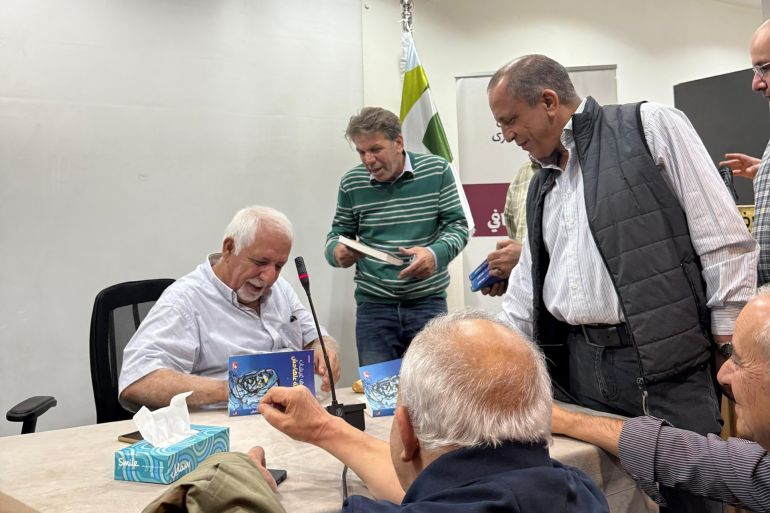 The writer signing his book 'The Epic of the Margins'.jpg