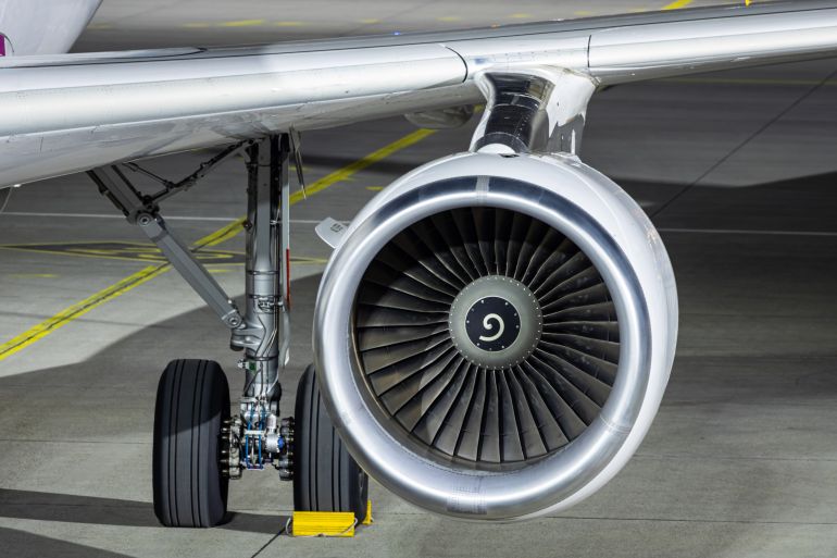 Graz, Austria - March 5, 2024: Closeup of jet engine and main gear of an Airbus A320. Airplane parked at night at the apron.