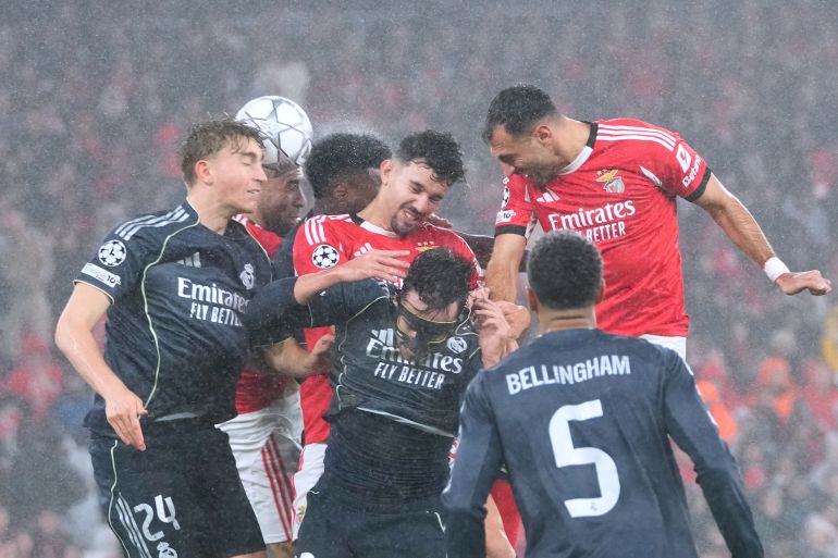 Benfica's Tomas Araujo, center, goes for a header against Real Madrid's Dean Huijsen, left, during a Champions League opening phase soccer match between Benfica and Real Madrid, in Lisbon, Wednesday, Jan. 28, 2026. (AP Photo/Armando Franca)