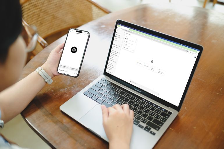 A woman using an AI chatbot service on a laptop and phone.