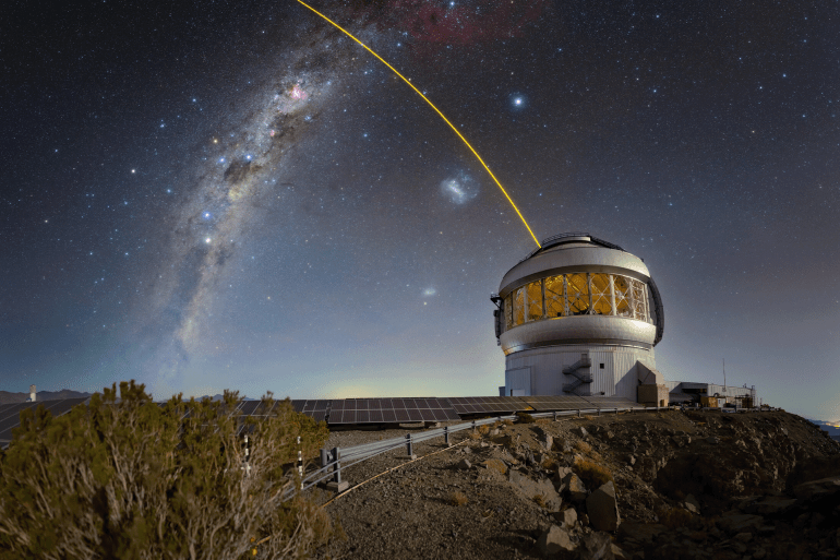 Gemini South, one half of the International Gemini Observatory, is seen here with its laser guide star in action. Both of the Gemini telescopes use laser guide stars to provide data for the calibration of their adaptive optics, systems of deformable mirrors that compensate for fluctuations in the upper atmosphere which can blur the images of distant stars and galaxies. The laser excites trace gas particles high in Earth’s upper atmosphere. Software then analyzes feedback from the laser to provide a model for the adaptive optics to map against. The laser guide stars can also be augmented by additional adaptive optics systems that use images of real stars from the telescope itself.