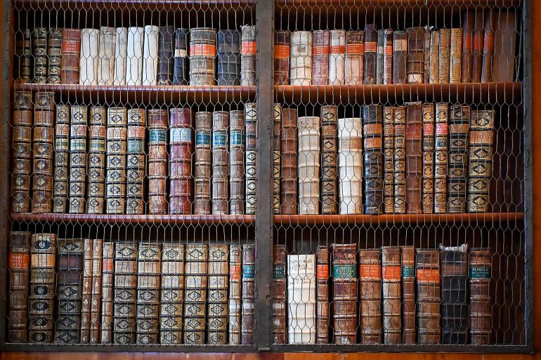 رفوف مكدسة بالمجلدات القديمة في قاعة مكتبة دير بانونهالما شمال غرب المجر (الأوروبية)