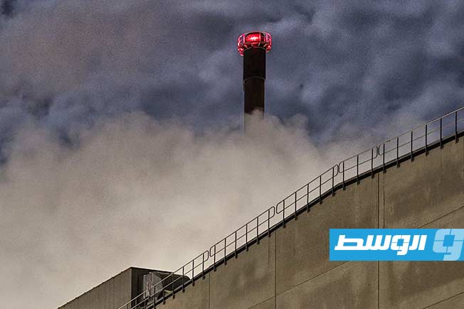 A picture of a paper factory in Sweden, surrounded by layers of shadows, concrete, and clouds on a dark November night.