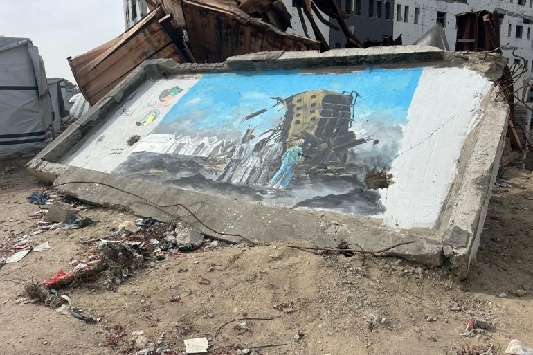 رسم جداري يلفت الانتباه إلى خطر المباني المهددة بالانهيار (الجزيرة)