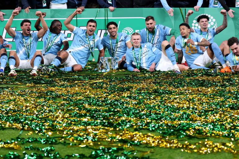 LONDON, ENGLAND - MARCH 22: Tijjani Reijnders, Matheus Nunes, Jeremy Doku, Rodri, Omar Marmoush, Erling Haaland, Gianluigi Donnarumma, Savinho, Nico O'Reilly and Rayan Cherki of Manchester City celebrate with the Carabao Cup trophy after the team's victory in the Carabao Cup Final match between Arsenal and Manchester City at Wembley Stadium on March 22, 2026 in London, England. (Photo by Julian Finney/Getty Images)